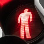 Detailed view of a red pedestrian crossing signal indicating stop.