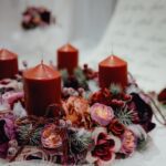 Warm, festive candle wreath adorned with floral decorations, perfect for Christmas table settings.