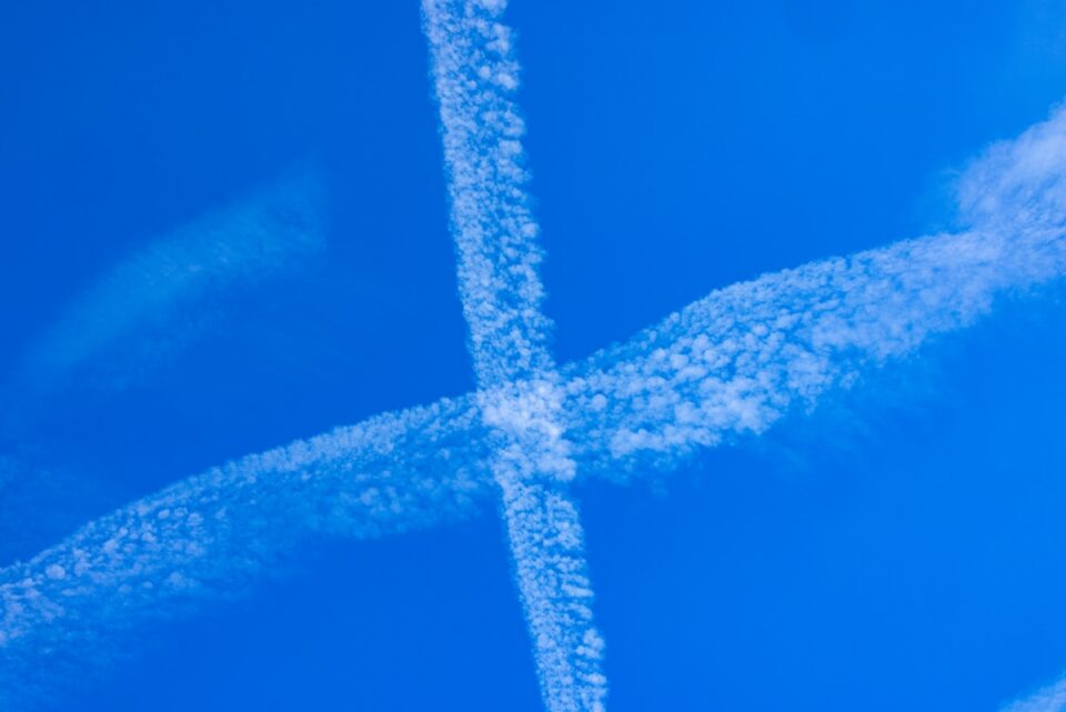 A group of airplanes flying through a blue sky