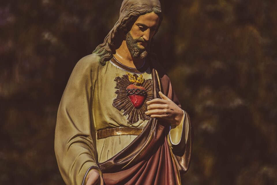 a statue of jesus holding his hands together