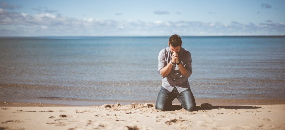 man kneeling down near shore