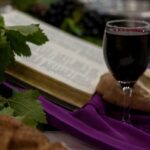 a glass of wine and a book on a table