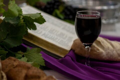 a glass of wine and a book on a table