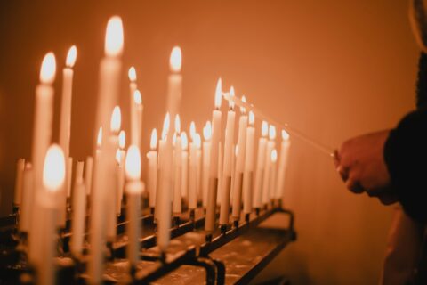 man standing near lighted candles