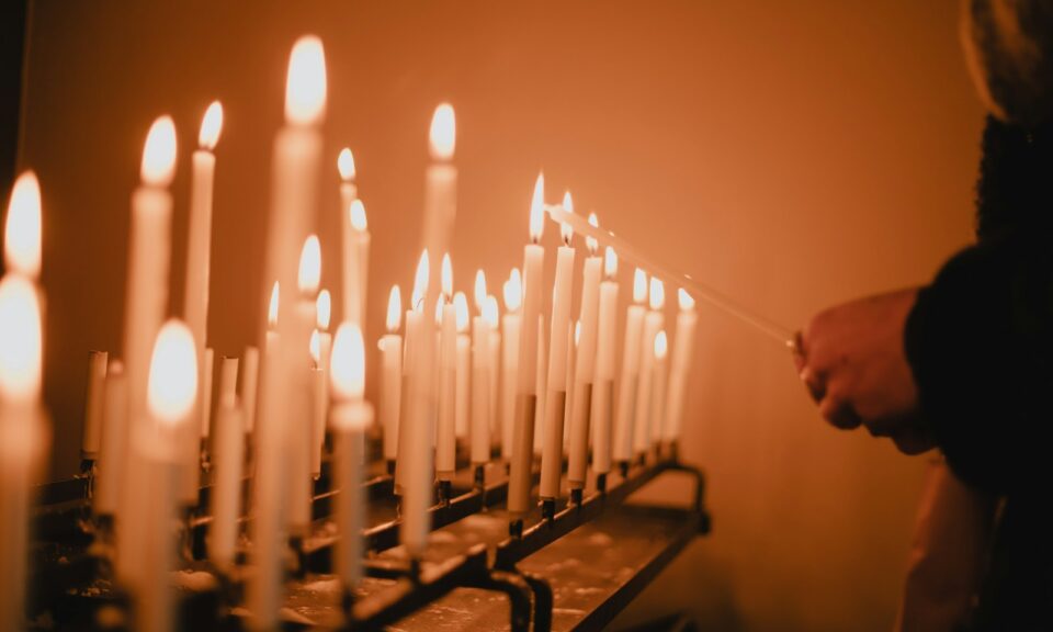 man standing near lighted candles