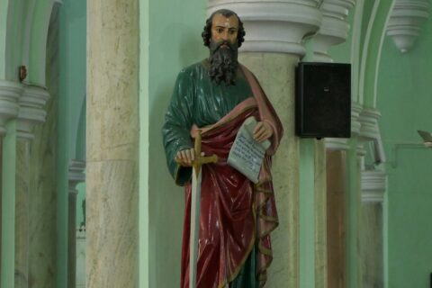 a statue of a man holding a book in a church