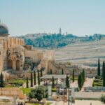 View of the historic Jerusalem walls and Al-Aqsa Mosque with a clear blue sky backdrop.