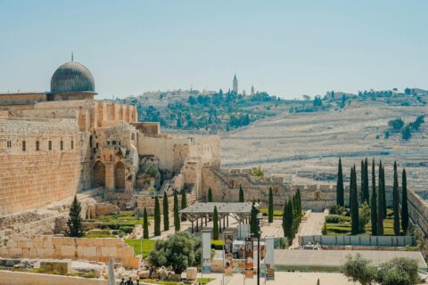 Zaboravljena povijest Jeruzalema: medaljon s menorom View of the historic Jerusalem walls and Al-Aqsa Mosque with a clear blue sky backdrop.