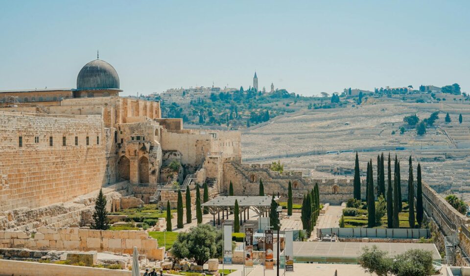 View of the historic Jerusalem walls and Al-Aqsa Mosque with a clear blue sky backdrop.