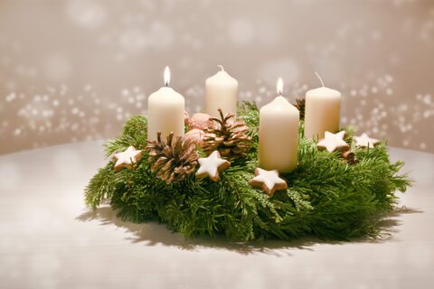 Fra Petar: Došašće traži obraćenje bdijte i molite Second Advent - decorated Advent wreath from fir and evergreen branches with white burning candles, tradition in the time before Christmas, warm background with festive bokeh and copy space
