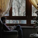 man sitting on sofa chair near Christmas tree