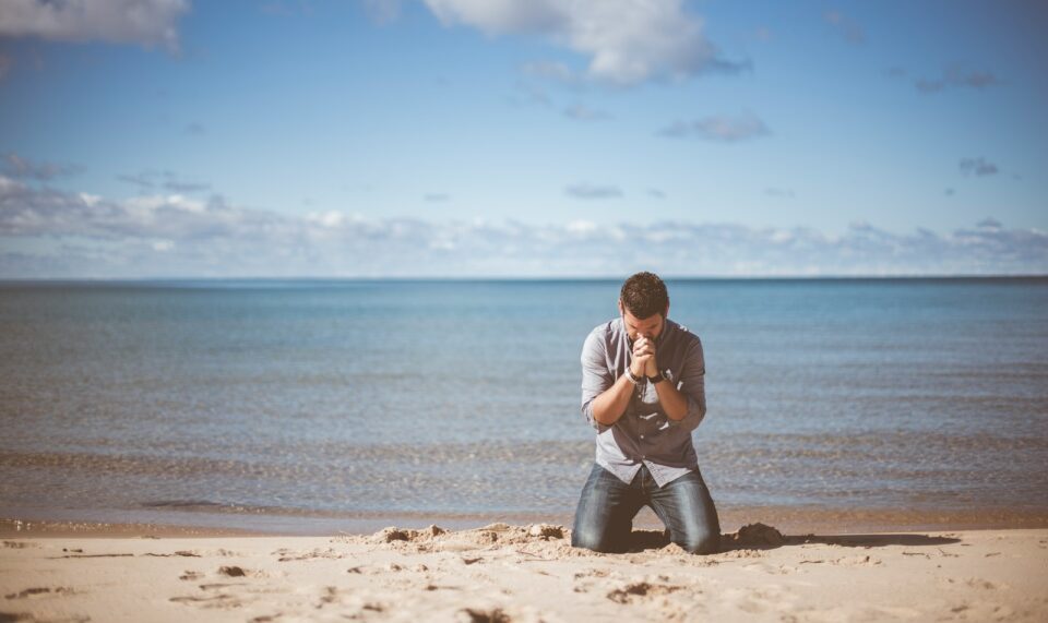 man kneeling down near shore