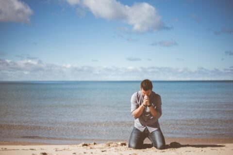man kneeling down near shore