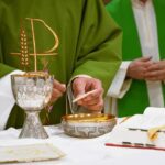 a priest is lighting a candle on a table