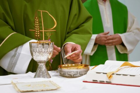 a priest is lighting a candle on a table