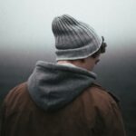 man wearing knit cap on grey background