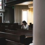 woman praying in cathedral