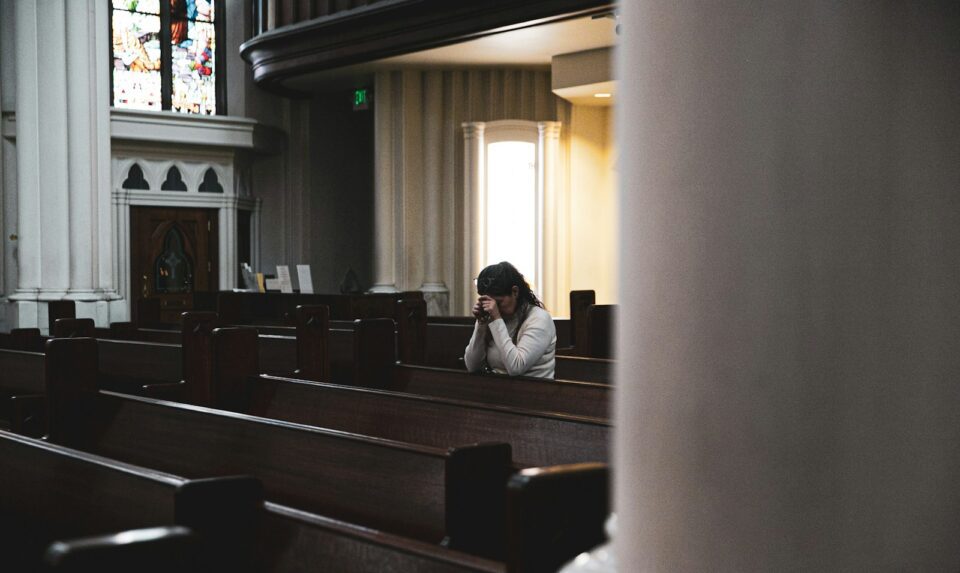 woman praying in cathedral