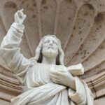 a statue of a person holding a book