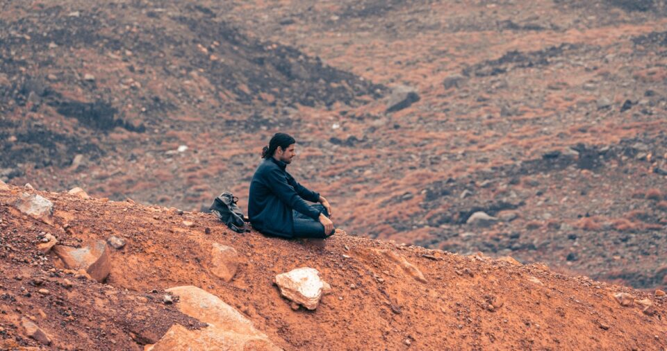 a man sitting on top of a dirt hill