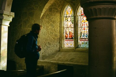 a man standing in front of a stained glass window