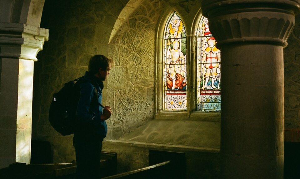 a man standing in front of a stained glass window