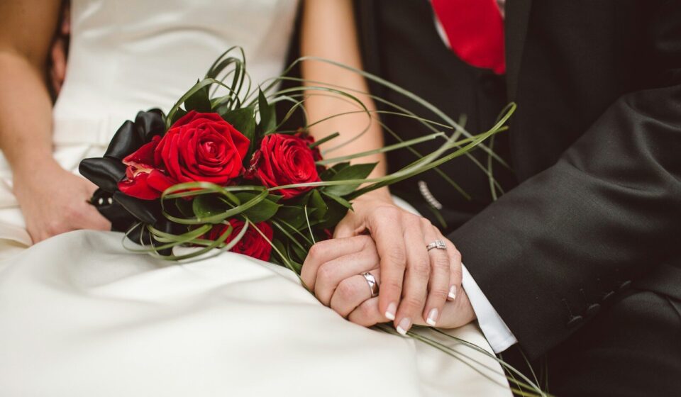 man holding red flowers