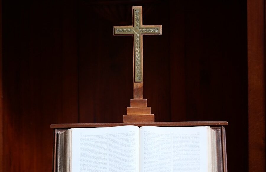 an open book with a cross on top of it