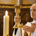 Mons. Stephen Rossetti podiže kalež tijekom mise u crkvi