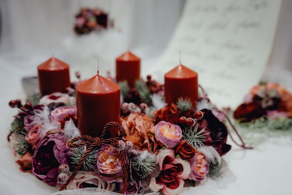 Warm, festive candle wreath adorned with floral decorations, perfect for Christmas table settings.