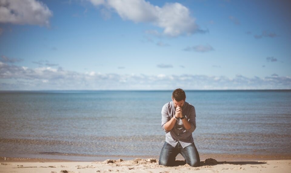man kneeling down near shore