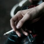 A person holding a cigarette in their hand