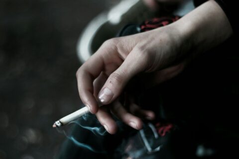 A person holding a cigarette in their hand