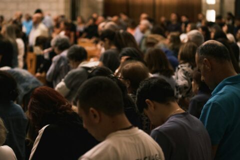 Svećenik upozorava: tri taktike kojima sotona napada naše misli A crowd of people bowing their heads in prayer.