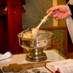 a person holding a spoon over a bowl of noodles