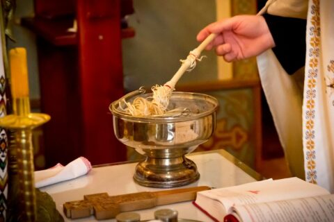 a person holding a spoon over a bowl of noodles