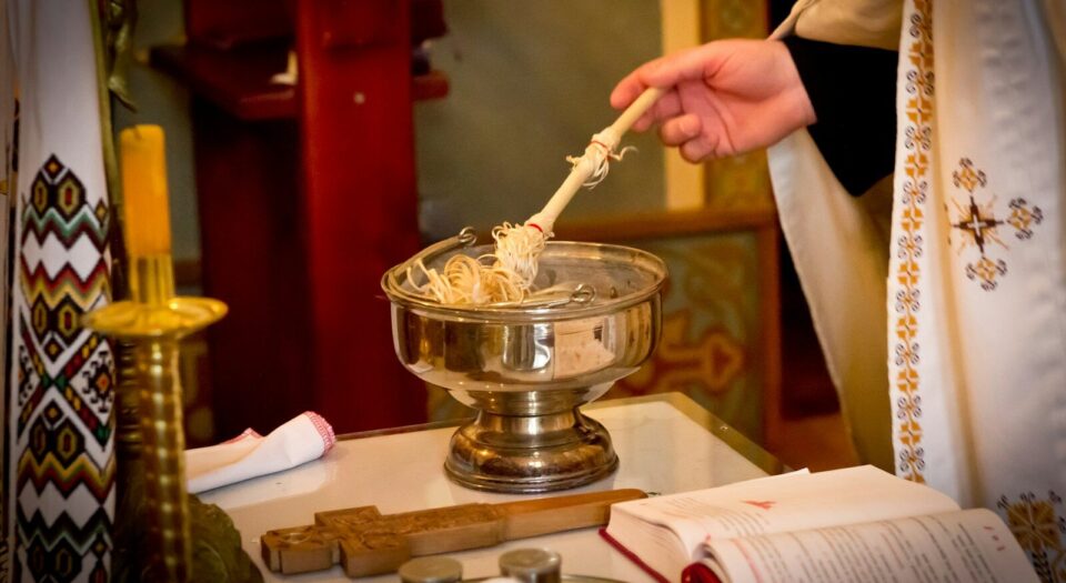 a person holding a spoon over a bowl of noodles