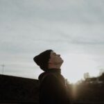 a man looking up into the sky at the sun