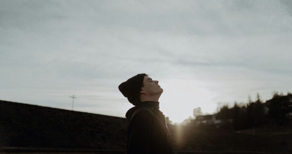 a man looking up into the sky at the sun