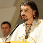 Vlč. Zlatko Sudac tijekom propovijedi govori vjernicima s raširenim rukama za ambonom u crkvi.