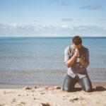 man kneeling down near shore