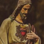a statue of jesus holding his hands together