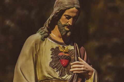 a statue of jesus holding his hands together