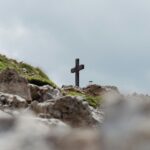 black cross on gray rocks under white sky during daytime