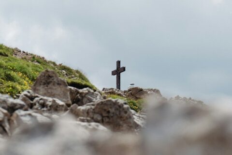 black cross on gray rocks under white sky during daytime