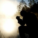 silhouette of kneeling man