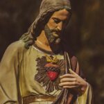 a statue of jesus holding his hands together
