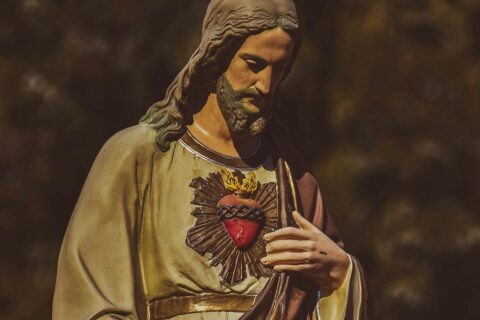 a statue of jesus holding his hands together