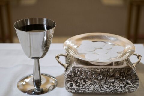 Zašto katolici poste jedan sat prije svete mise i pričesti? Elegant display of a silver chalice with wine and wafers in a sacred setting, symbolizing the Eucharist.