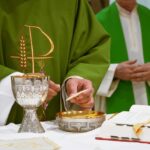 a priest is lighting a candle on a table